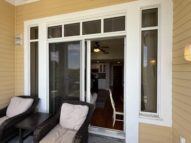 a living room with furniture kitchen view and a wooden floor