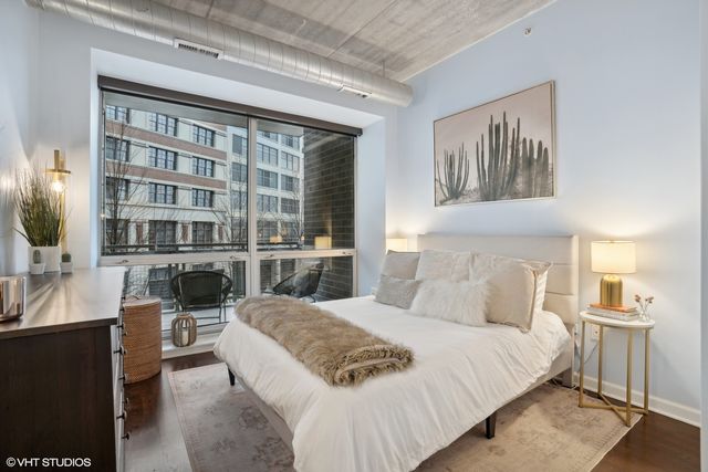 a bedroom with a large bed and a view of living room