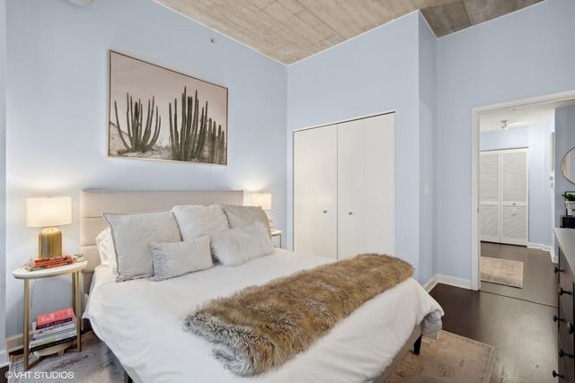 a bedroom with a bed and a painting on the wall