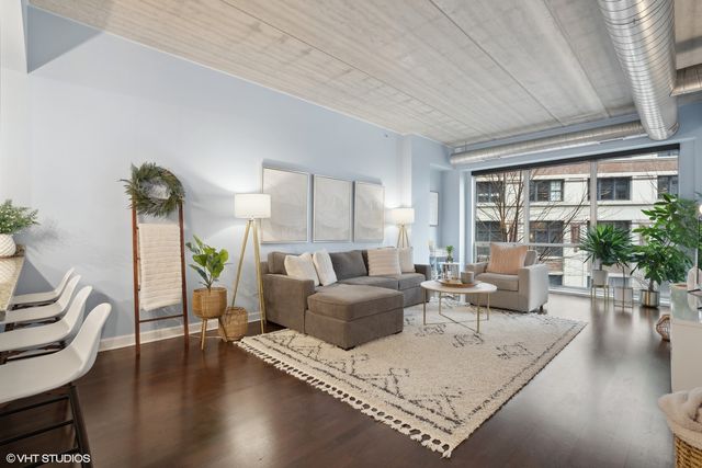 a living room with furniture hard wood floor and a table