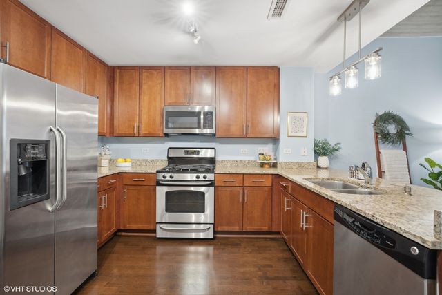 a kitchen with stainless steel appliances granite countertop a sink stove and refrigerator