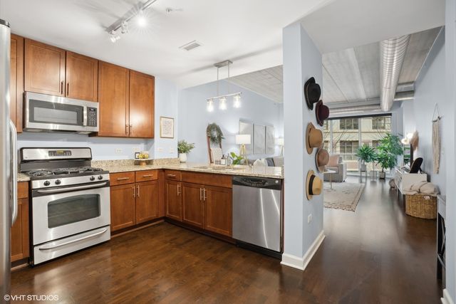 a kitchen with stainless steel appliances kitchen island granite countertop a stove a sink and a refrigerator
