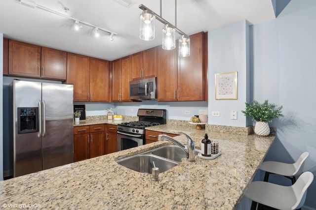 a kitchen with granite countertop a sink stove and refrigerator