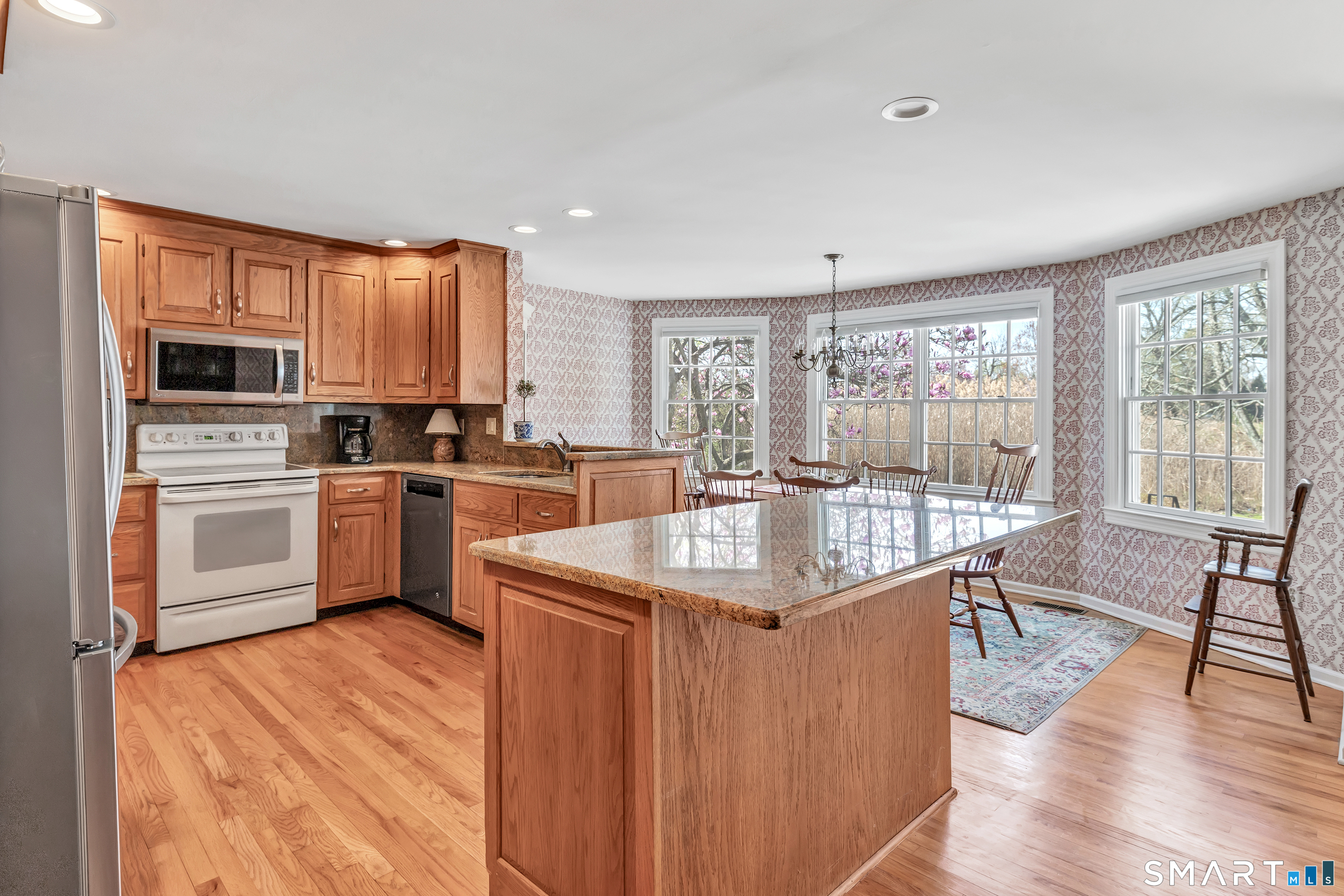 364 Beach Road Fairfield, CT 06824 - Photo 19 of 40 a kitchen with stainless steel appliances granite countertop a sink stove and refrigerator