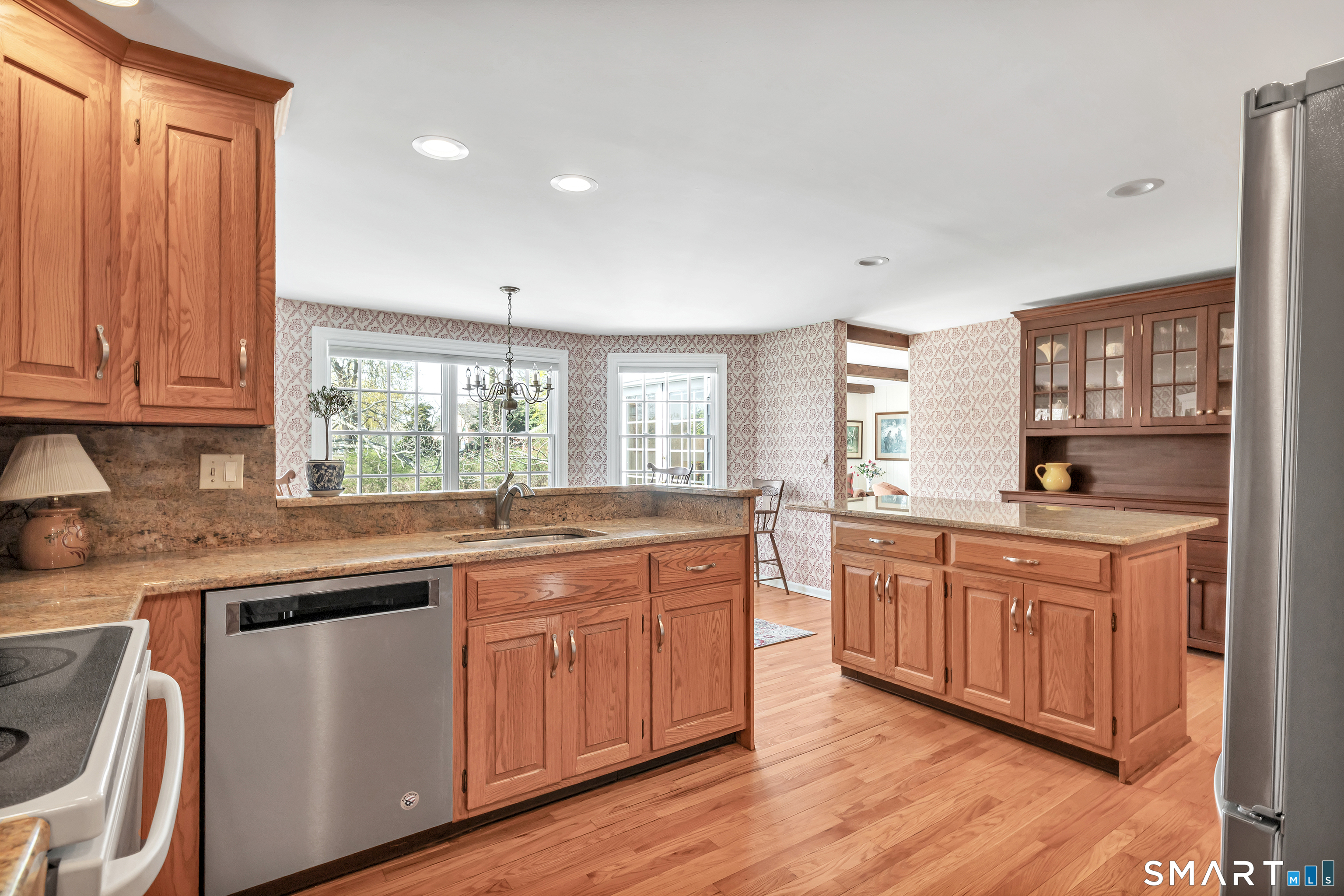 364 Beach Road Fairfield, CT 06824 - Photo 21 of 40 a kitchen with stainless steel appliances granite countertop wooden cabinets a sink and dishwasher with wooden floor
