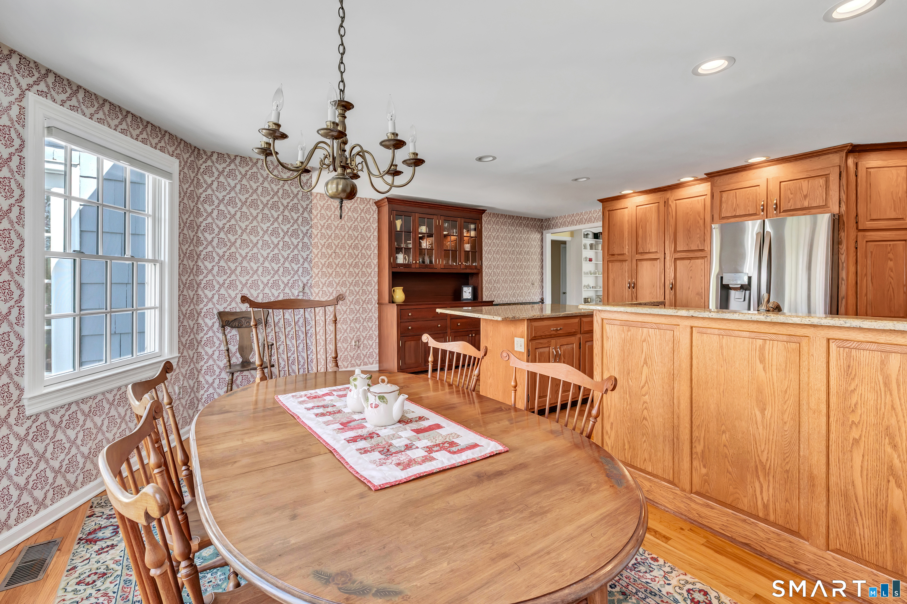 364 Beach Road Fairfield, CT 06824 - Photo 24 of 40 a living room with couches a dining table and chairs with wooden floor