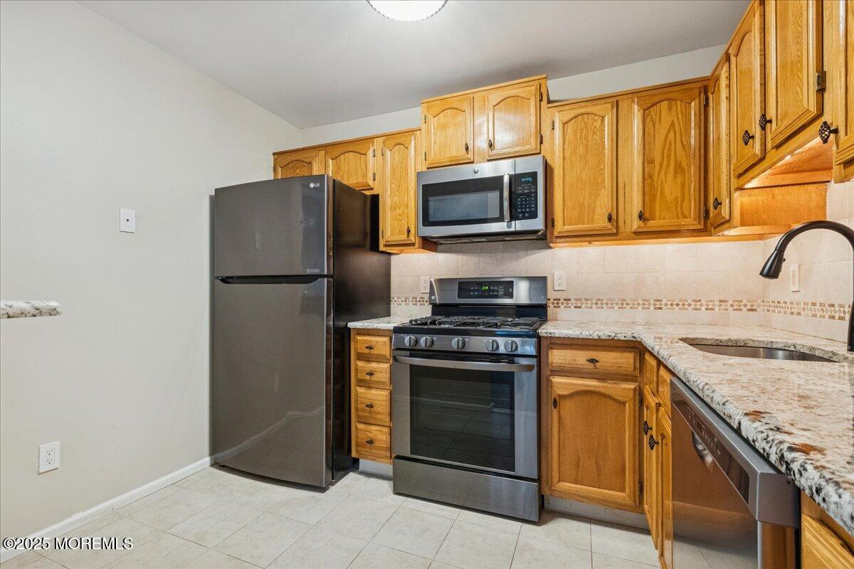 8 White Oak Court Howell, NJ 07731 - Photo 10 of 17 a kitchen with stainless steel appliances granite countertop a refrigerator stove and microwave