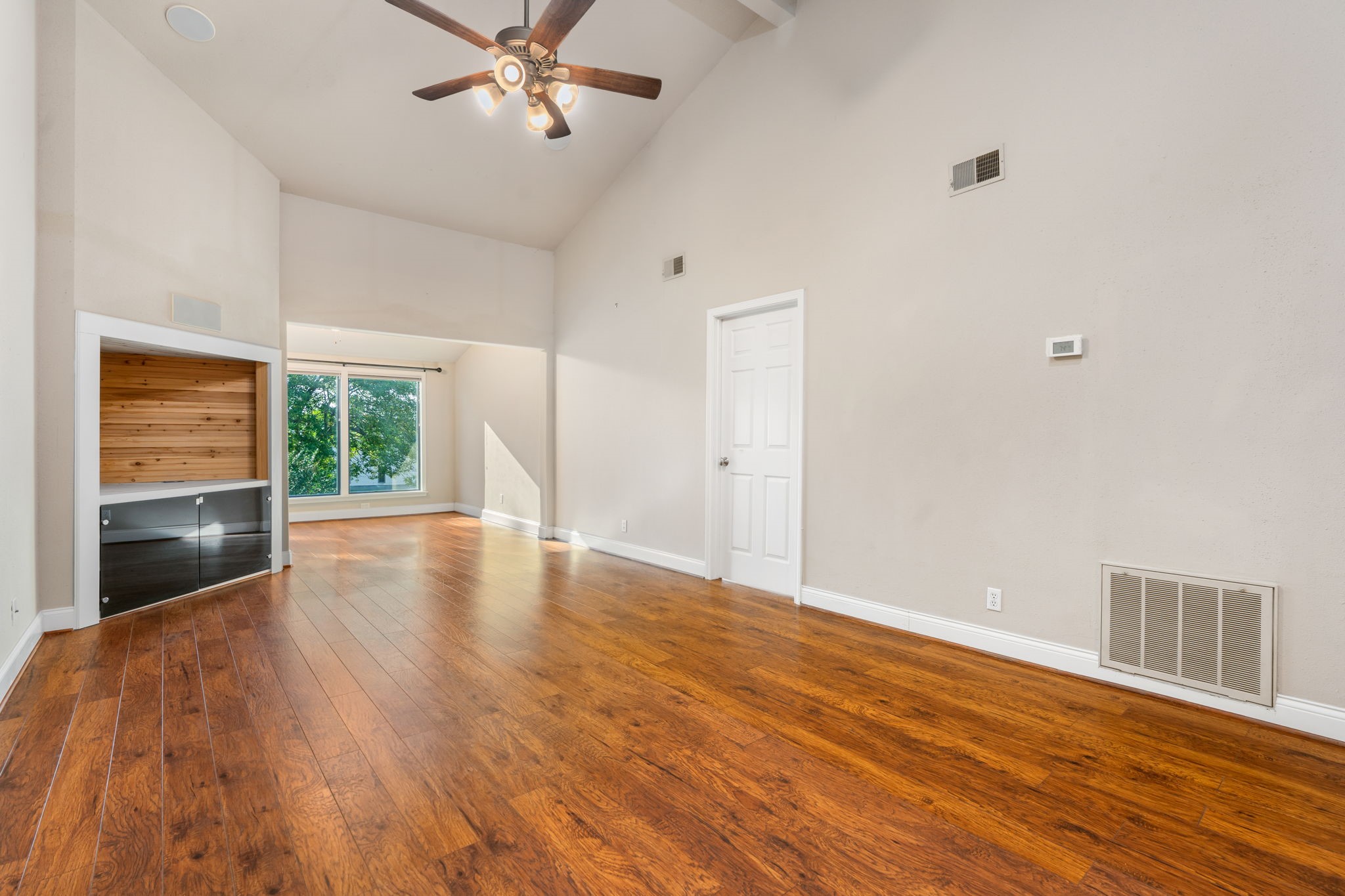 204 Lakeview Terrace, Unit G Conroe, TX 77356 - Photo 11 of 26 a view of an empty room with a window and wooden floor