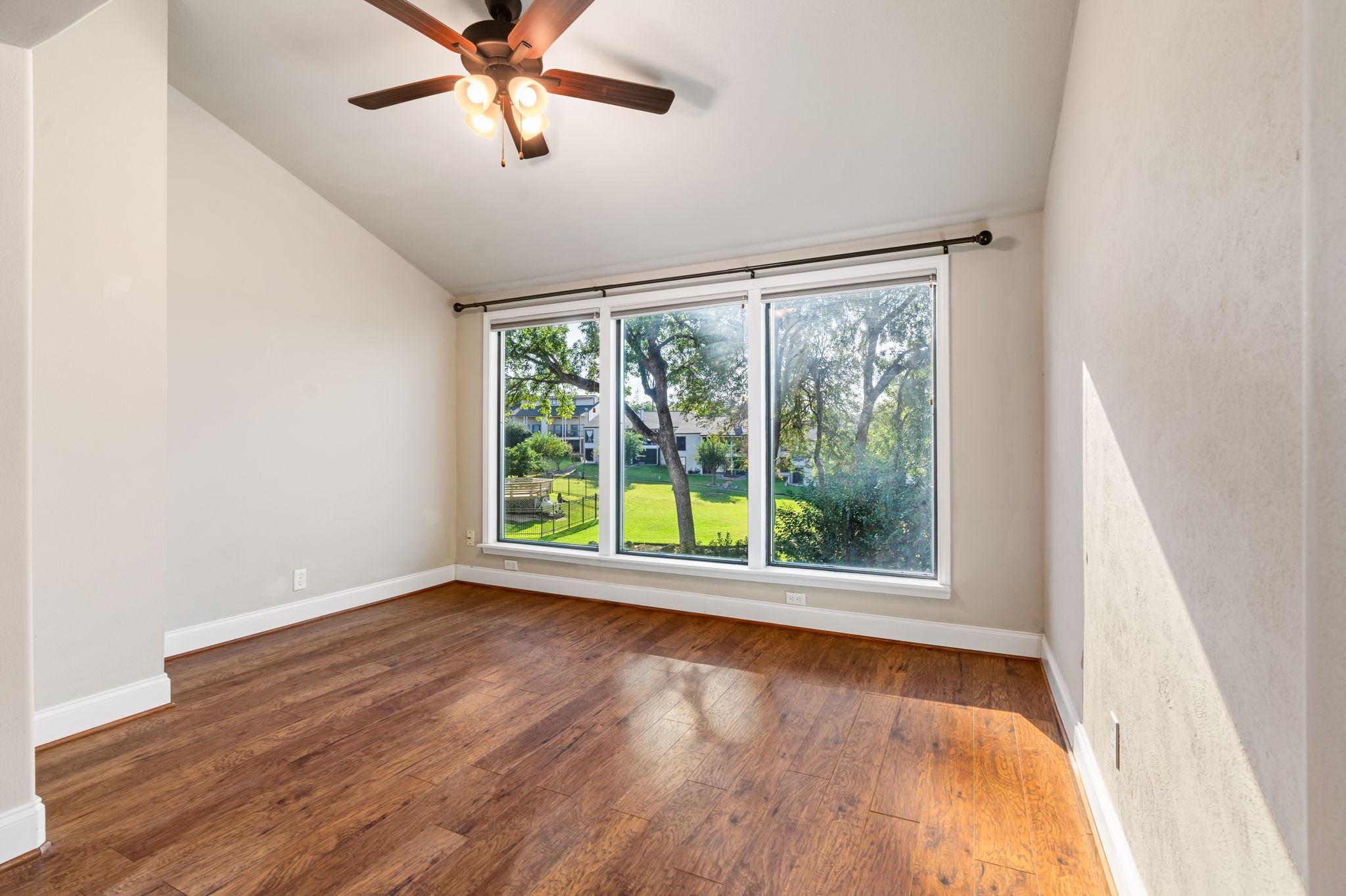 204 Lakeview Terrace, Unit G Conroe, TX 77356 - Photo 12 of 26 a view of an empty room with wooden floor and a window