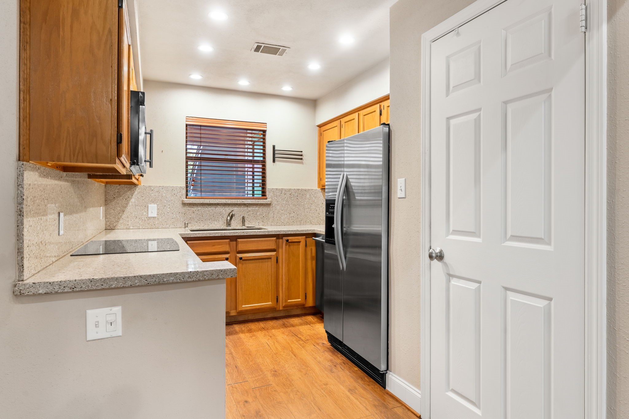 204 Lakeview Terrace, Unit G Conroe, TX 77356 - Photo 14 of 26 a kitchen with stainless steel appliances granite countertop a refrigerator and a sink