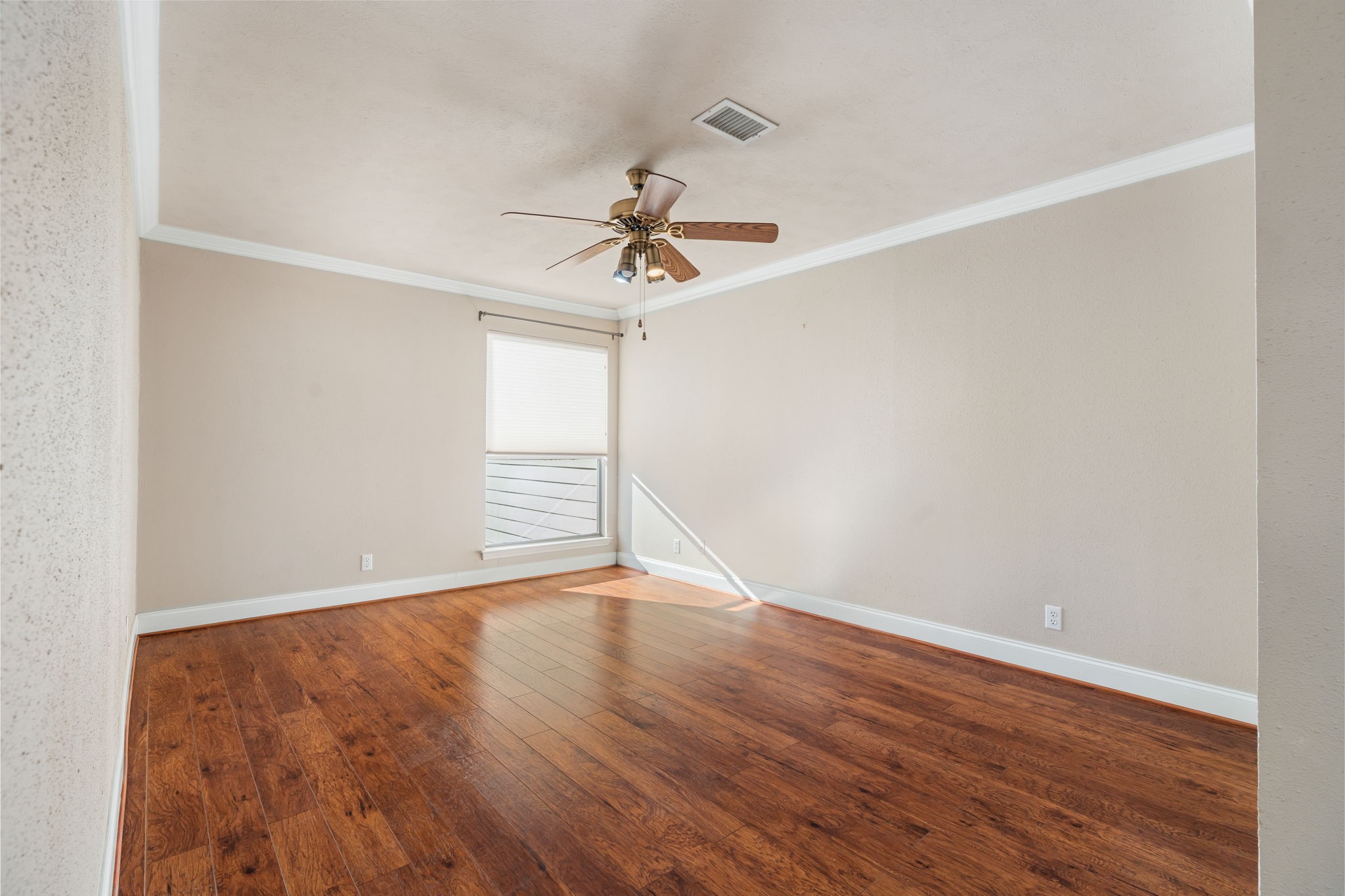 204 Lakeview Terrace, Unit G Conroe, TX 77356 - Photo 18 of 26 a view of an empty room with wooden floor and a ceiling fan