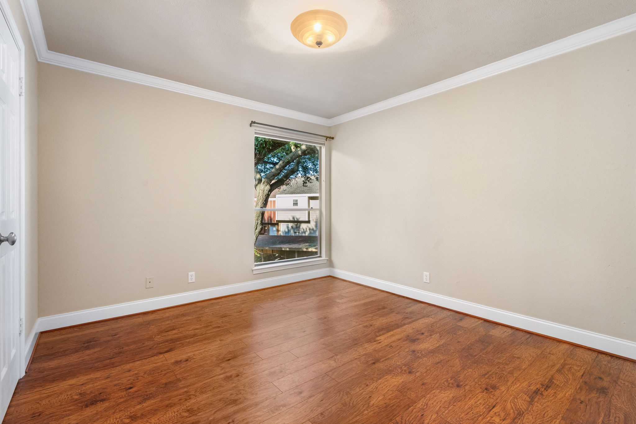 204 Lakeview Terrace, Unit G Conroe, TX 77356 - Photo 22 of 26 a view of an empty room with wooden floor and a window