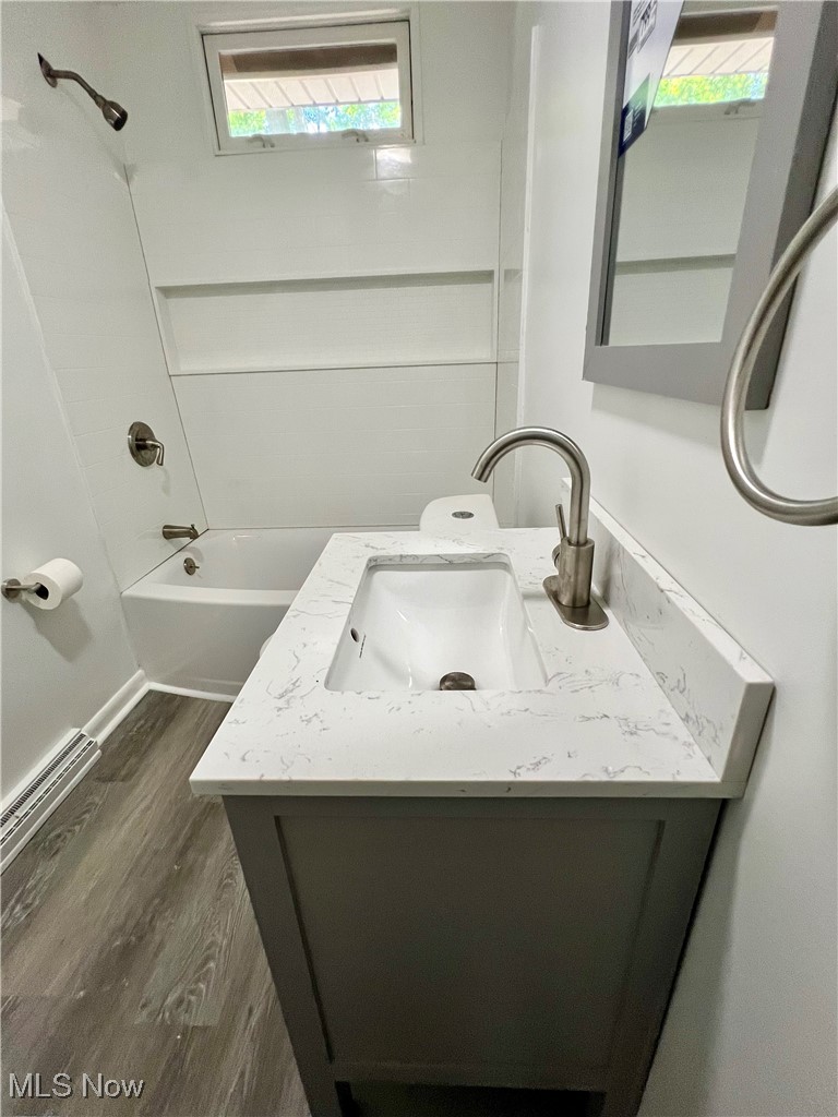 2972 North Turkeyfoot Road Akron, OH 44319 - Photo 8 of 32 Bathroom featuring vanity, shower / tub combination, wood finished floors, and baseboard heating