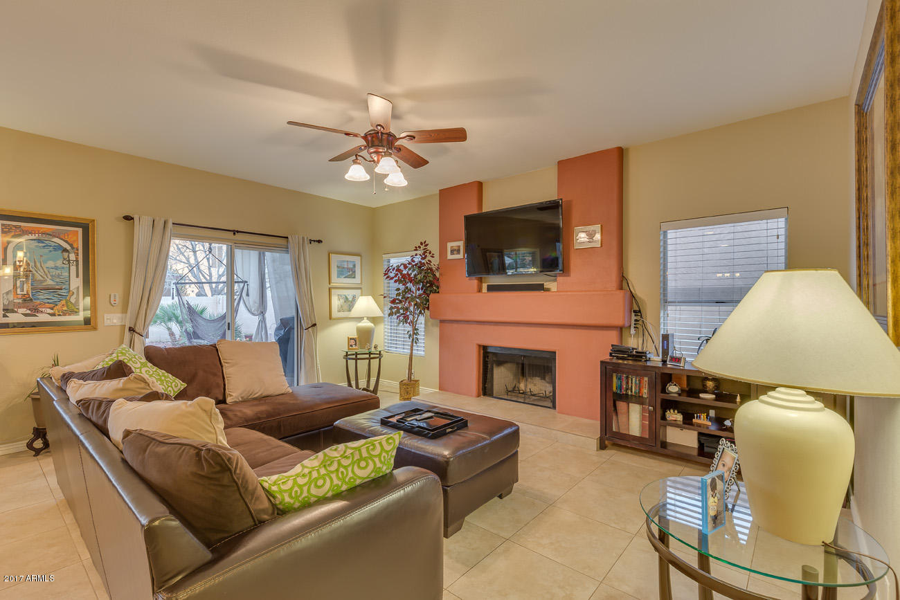 11255 West Piccadilly Road Avondale, AZ 85392 - Photo 13 of 29 a living room with furniture a fireplace and a flat screen tv