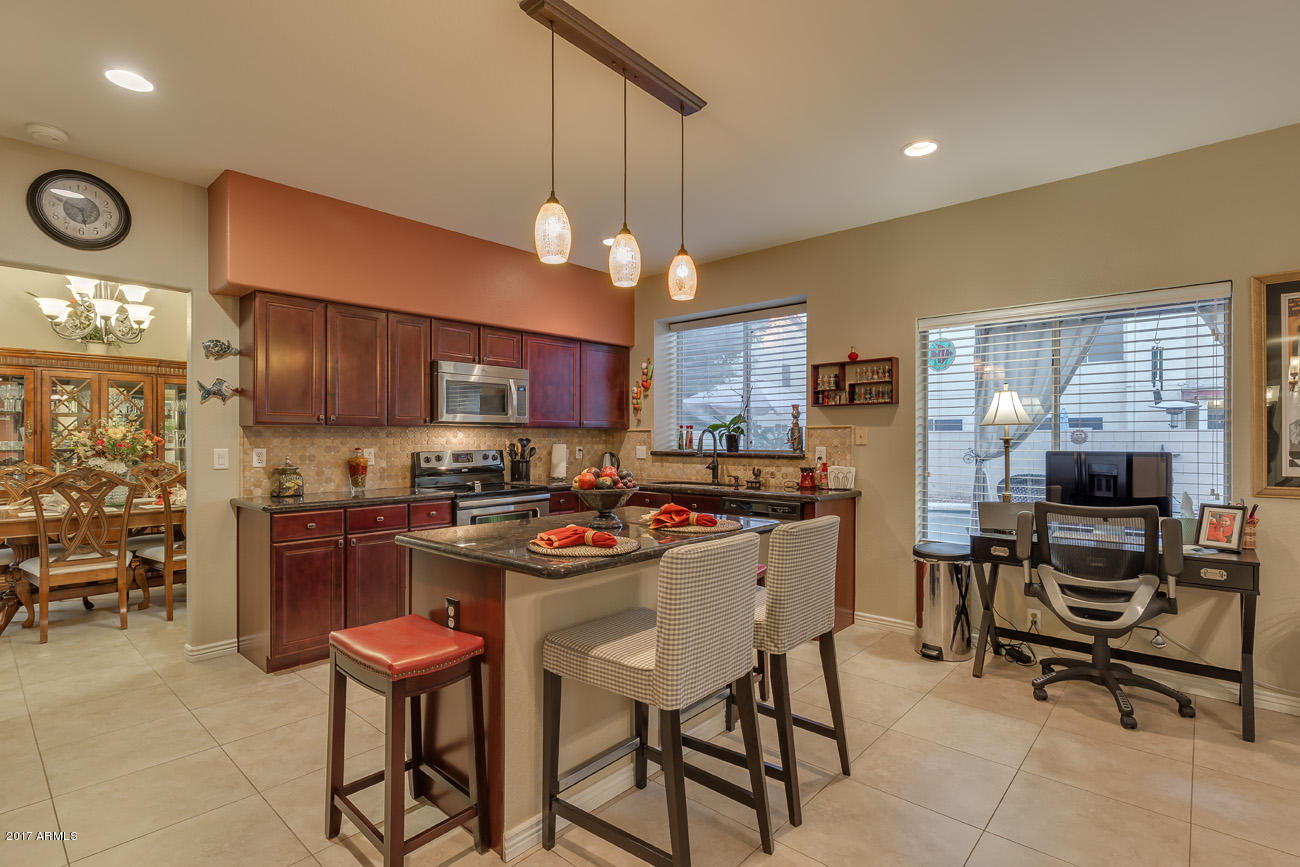 11255 West Piccadilly Road Avondale, AZ 85392 - Photo 17 of 29 a kitchen with stainless steel appliances granite countertop a stove top oven a refrigerator a sink and chairs