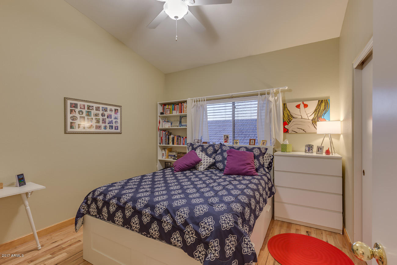 11255 West Piccadilly Road Avondale, AZ 85392 - Photo 22 of 29 a bedroom with a large bed and a chandelier