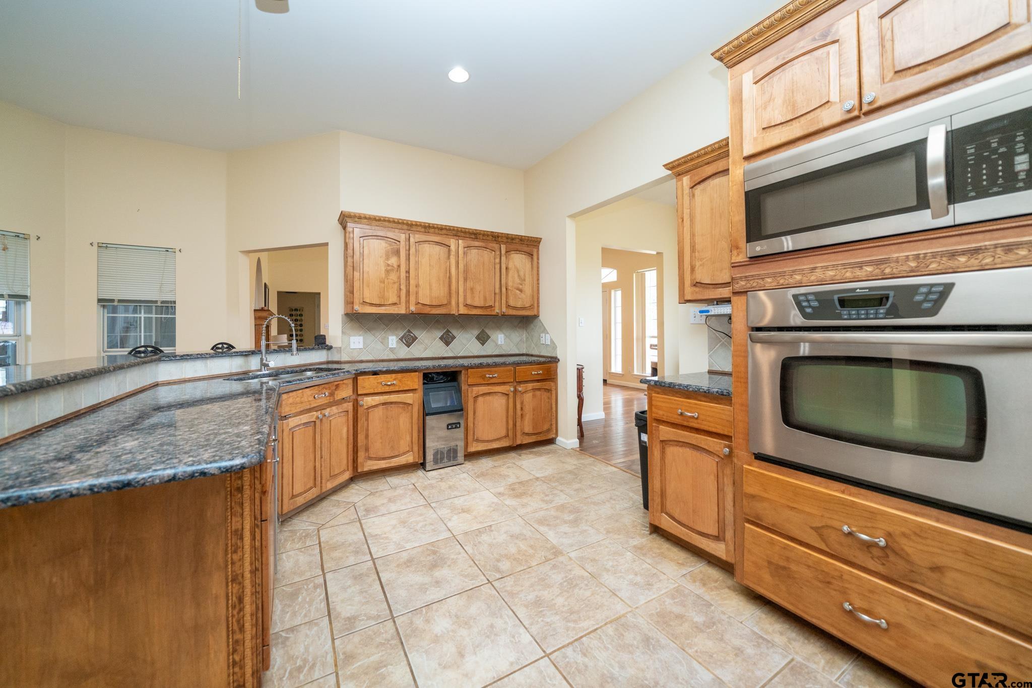2266 Big Woods Road Longview, TX 75605 - Photo 15 of 48 a kitchen with stainless steel appliances granite countertop a stove a sink and a microwave