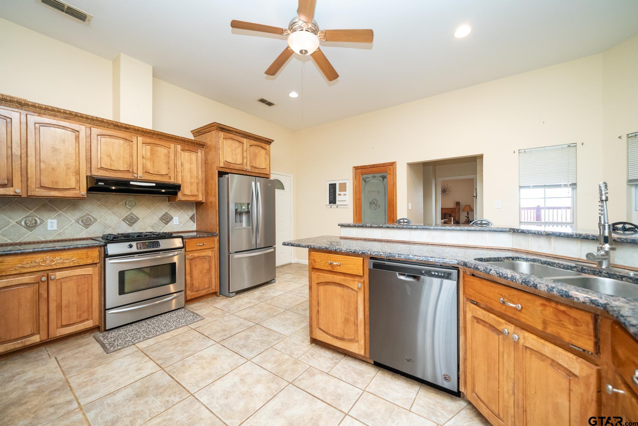 2266 Big Woods Road Longview, TX 75605 - Photo 17 of 48 a kitchen with stainless steel appliances granite countertop a stove sink and cabinets