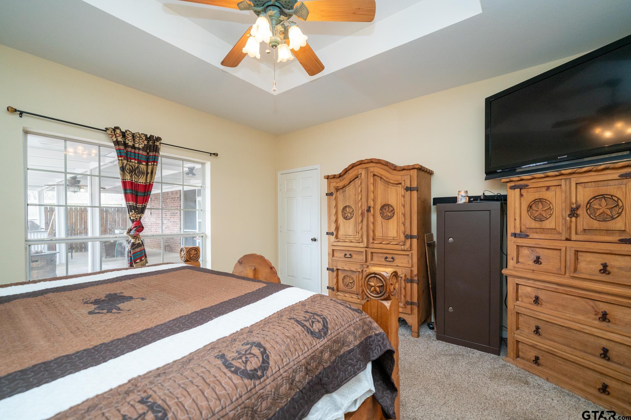 2266 Big Woods Road Longview, TX 75605 - Photo 23 of 48 a bedroom with a bed and flat tv screen on wall