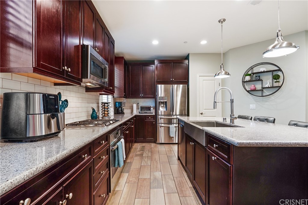 14865 West Maple Terrace Panorama City, CA 91402 - Photo 13 of 36 a kitchen with stainless steel appliances granite countertop a sink a stove and a refrigerator