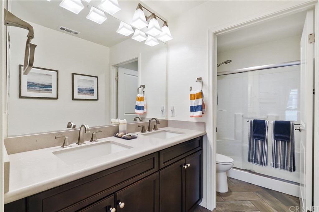 14865 West Maple Terrace Panorama City, CA 91402 - Photo 27 of 36 a bathroom with a sink a large mirror and a shower