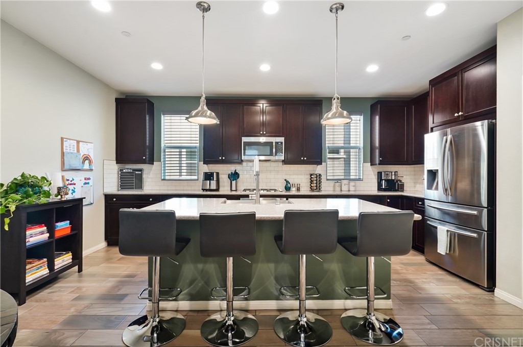 14865 West Maple Terrace Panorama City, CA 91402 - Photo 9 of 36 a kitchen with a table chairs refrigerator and microwave