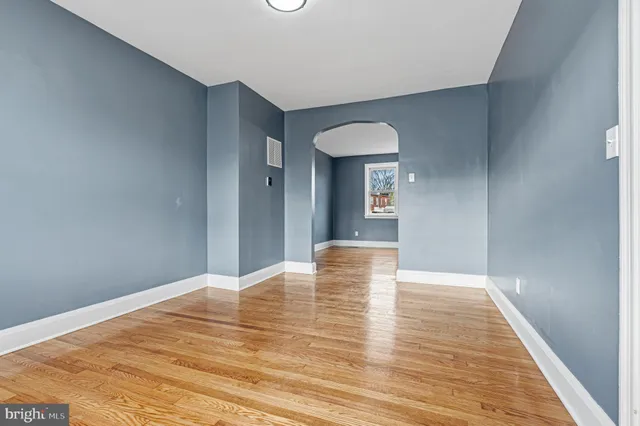 a view of empty room with wooden floor