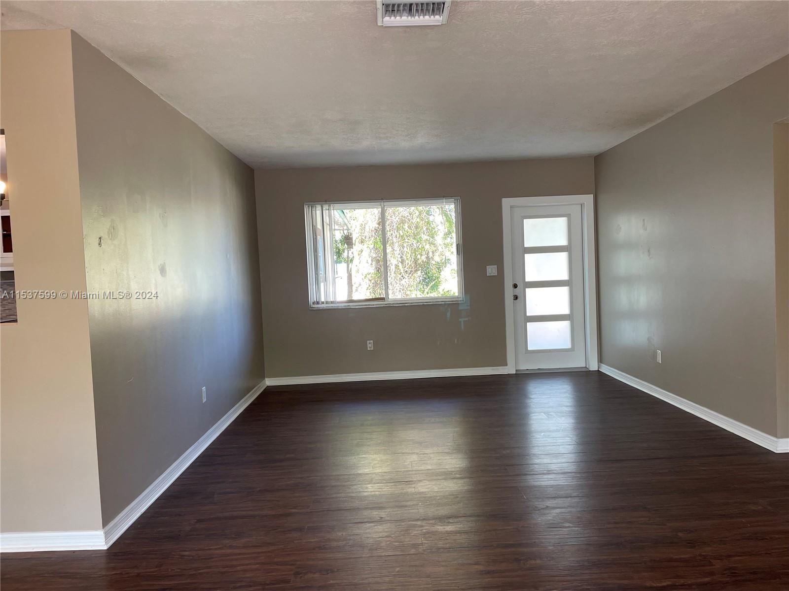 19640 Whispering Pines Road Cutler Bay, FL 33157 - Photo 3 of 31 an empty room with wooden floor and windows