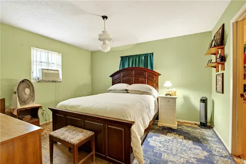 a bedroom with a bed a dresser and potted plant