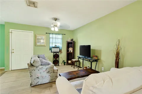 a living room with furniture a chandelier and a flat screen tv