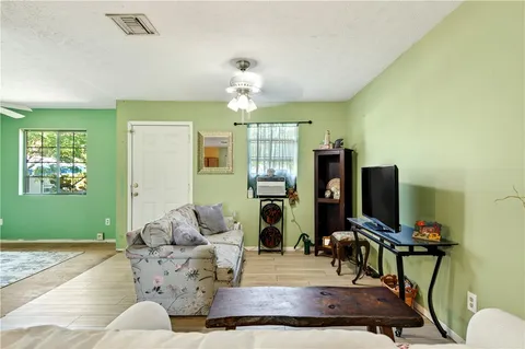a living room with furniture a chandelier and a flat screen tv
