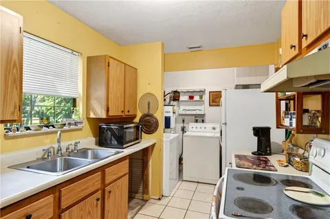 a kitchen with stainless steel appliances a sink a stove a refrigerator and wooden cabinets