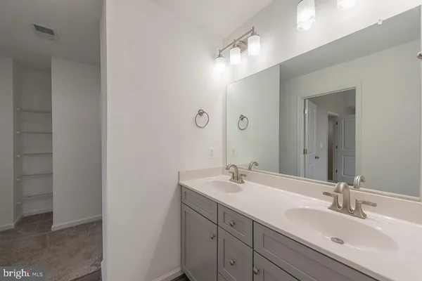 a bathroom with a double vanity sink and a mirror