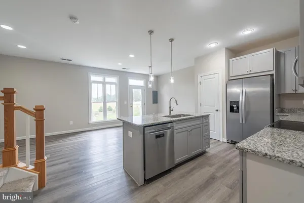 a large kitchen with stainless steel appliances kitchen island granite countertop a sink and a stove