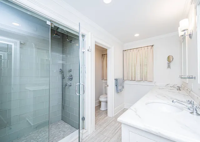 a spacious bathroom with a granite countertop sink a mirror and shower