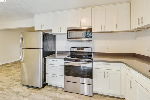 a kitchen with granite countertop white cabinets and a sink
