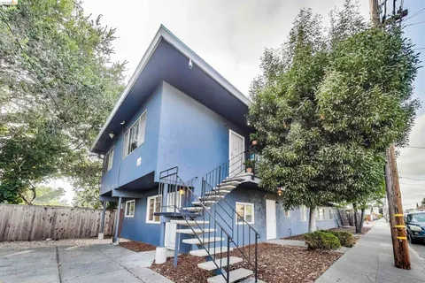 a front view of a house with a tree