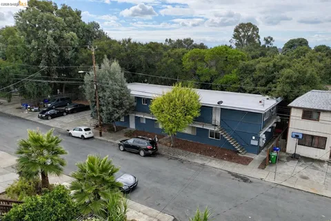 an aerial view of a house with garden space and car parked