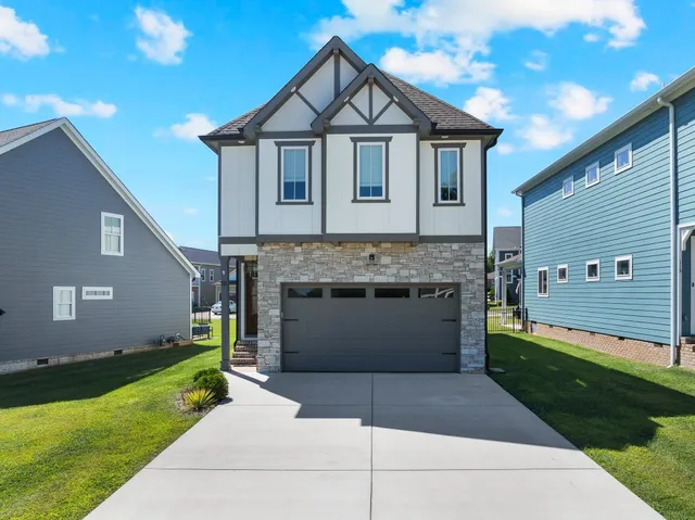a front view of a house with a yard and garage