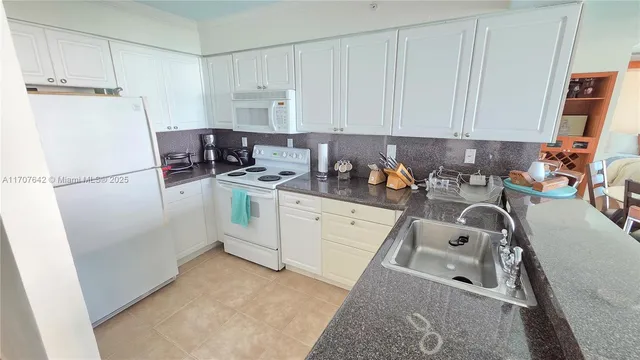 a kitchen with a refrigerator sink stove and cabinets