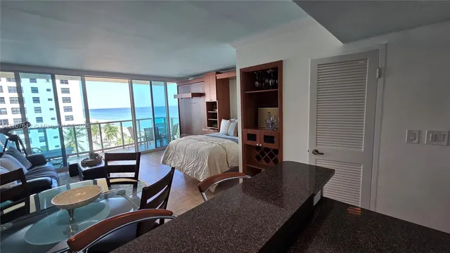 a living room with furniture and floor to ceiling windows