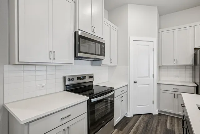 a kitchen with white cabinets stainless steel appliances and sink