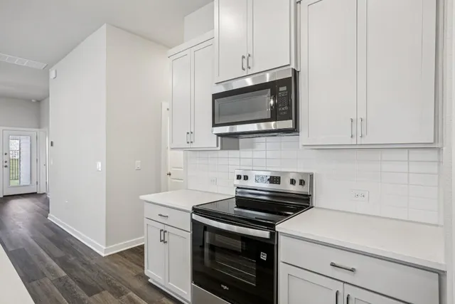 a kitchen with white cabinets stainless steel appliances and sink