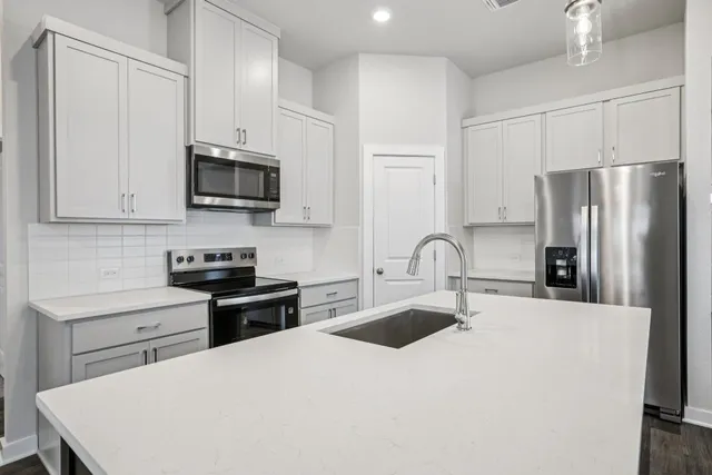 a kitchen with stainless steel appliances a stove refrigerator sink and cabinets
