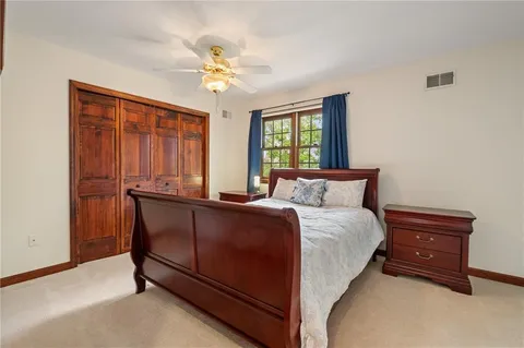 a bedroom with a bed and a painting on the wall