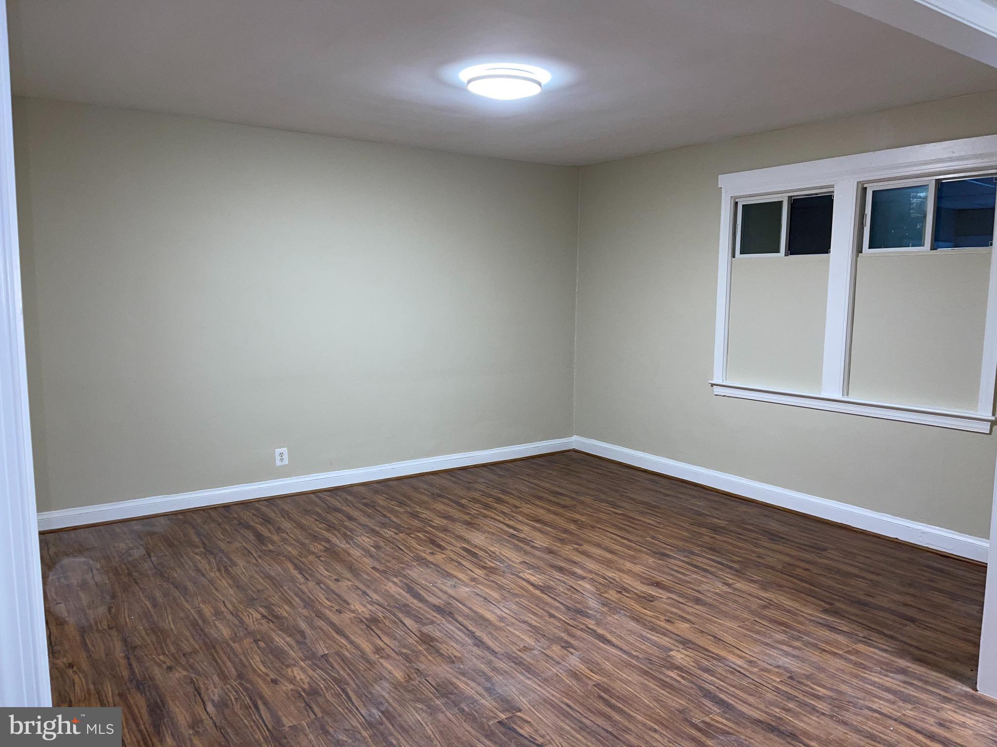 2210 Nicholson Street Southeast, Unit 3 Washington, DC 20020 - Photo 13 of 25 a view of an empty room with wooden floor and a window