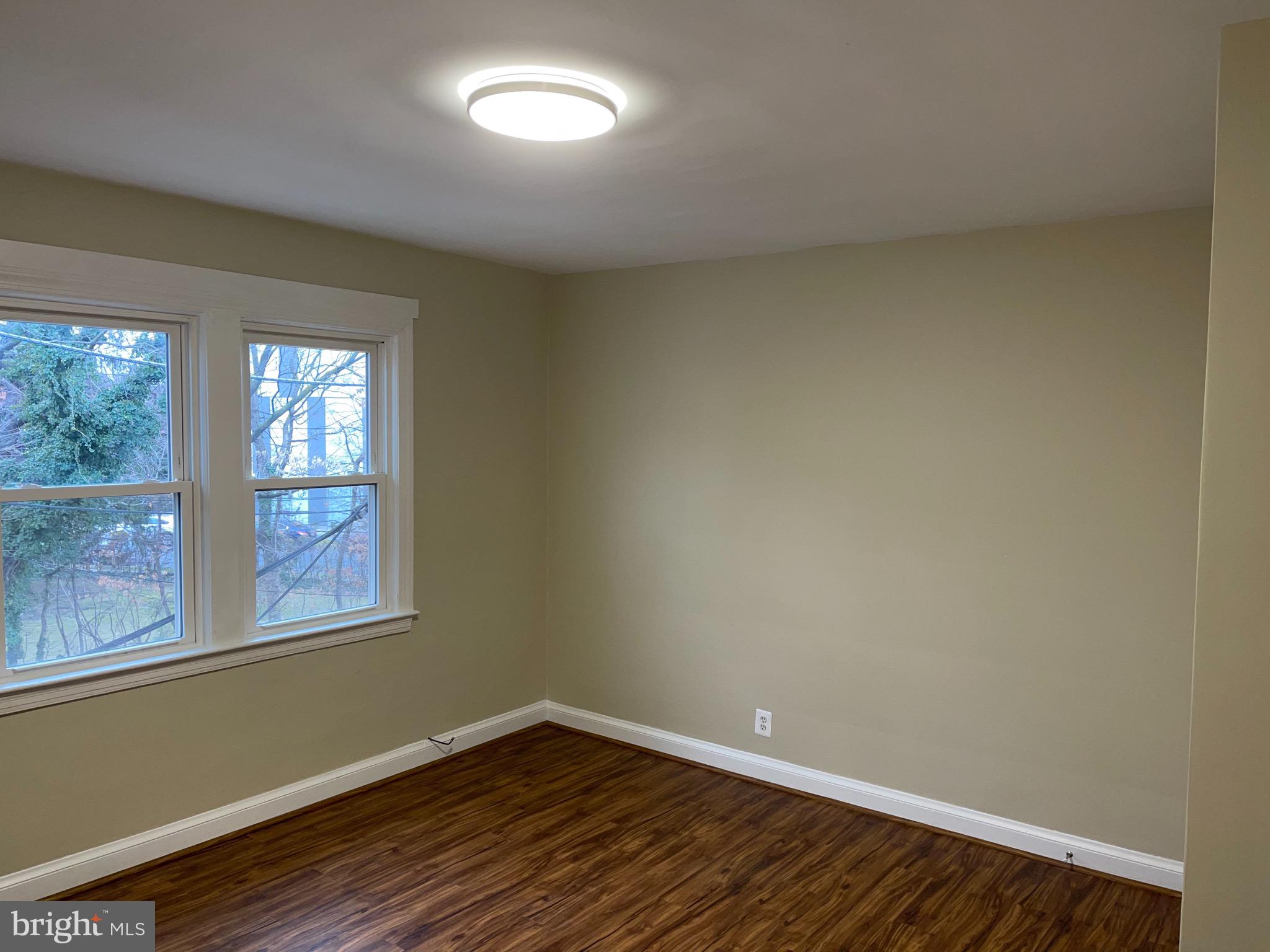 2210 Nicholson Street Southeast, Unit 3 Washington, DC 20020 - Photo 5 of 25 an empty room with wooden floor and windows
