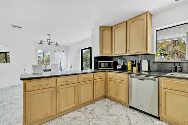 a kitchen with cabinets appliances and a sink