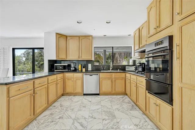 a kitchen with stainless steel appliances granite countertop a stove a sink and a refrigerator