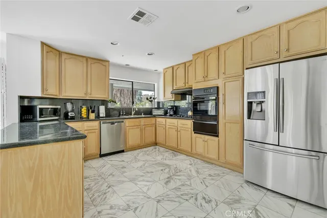a kitchen with stainless steel appliances granite countertop a refrigerator sink and cabinets